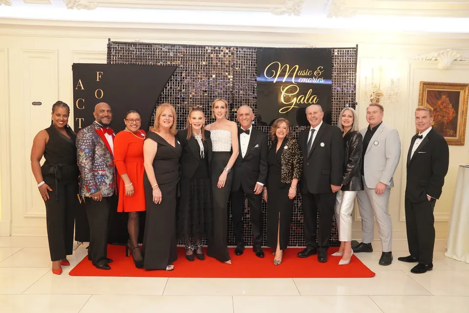 Act Now Foundation team and guests posing at the Music & Memories Gala step-and-repeat